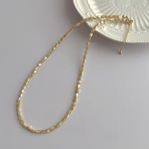 Detail of champagne shell bead necklace with gold lobster clasp and extension chain