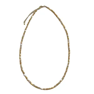 Minimalist shell beaded necklace with gold lobster clasp for a stylish beach holiday look