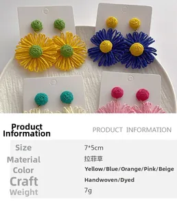 Detail van handgemaakte raffia bloemoorbellen met focus op de weefstructuur en diverse kleuren