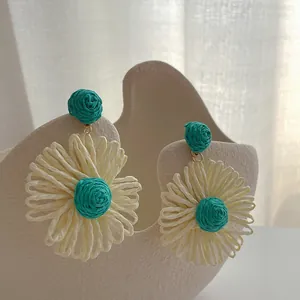 Handgemaakte raffia bloemoorbellen in beige en groenblauw voor een strandvakantie