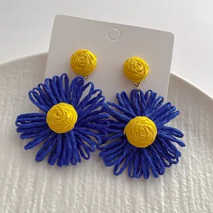 Handgemaakte raffia bloemenoorbellen in geel en blauw, perfect voor strandvakanties
