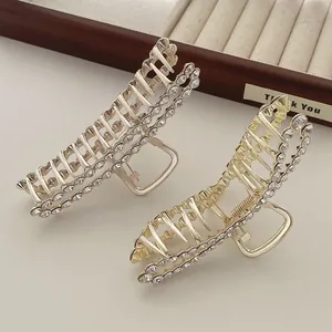 Macro detail of gold and silver metal hair claws set with sparkling pave rhinestones