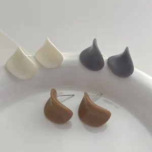 Détails des boucles d'oreilles irrégulières en résine blanc, gris foncé et caramel