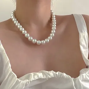 Gros plan d'un collier de perles blanches de 12mm montrant un éclat élégant et pur