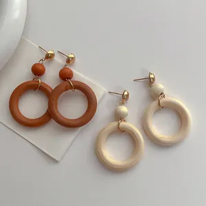 Detailed top view of natural wooden hoop earrings in dark brown and cream tones