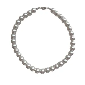 Élégant collier de perles blanches à un rang avec fermoir cœur argenté sur fond blanc