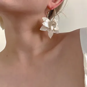 Detailansicht der französischen Retro-Acryl-Blumenohrringe mit Goldreif an Modell