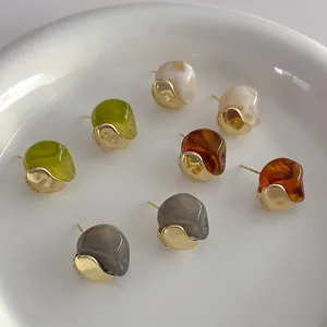 Irregular resin stud earrings in olive green, cream and amber with gold metal bases