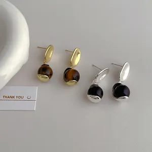 Chic gold and silver earrings with tiger eye stone and black marble pendants