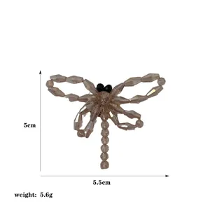 Vue détaillée d'une broche libellule en perles montrant les dimensions de 5,5cm sur 5cm