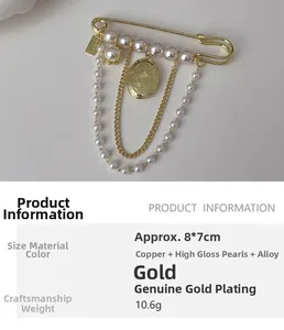Detail of vintage gold brooch featuring layered metal chains and a high-luster pearl charm