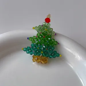 Vue détaillée d'une broche sapin de Noël en cristal vert avec des perles facettées