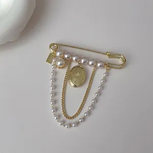 Vintage gold brooch with white pearls and hanging chain with engraved oval pendant
