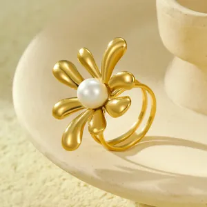 Detailed macro view of a gold flower ring with pearl inlay on a ceramic tray
