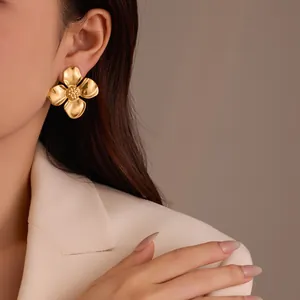 Große vergoldete Edelstahl Blumenohrringe im Retro-Stil an einem Modell gezeigt