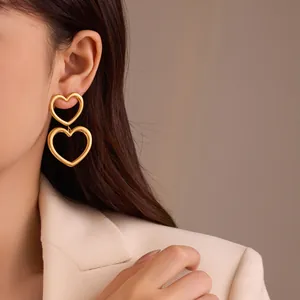Ohrringe aus 18K vergoldetem Edelstahl mit hohlem Herzanhänger an einem Model
