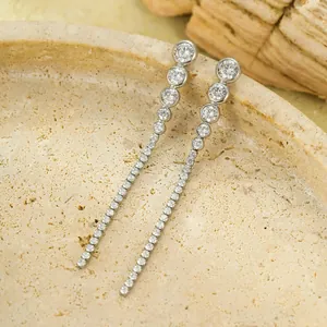 Détail de boucles d'oreilles pampilles argentées avec zircons en dégradé sur pierre