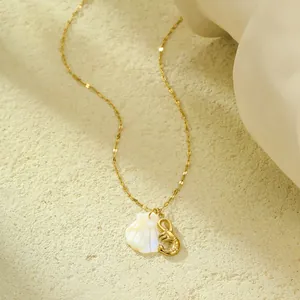 Détail du collier en chaîne dorée avec pendentif coquillage et breloque scorpion chic