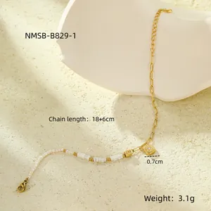 Dettaglio del bracciale dorato regolabile con perline, pendente in zircone e moschettone