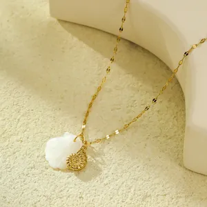 Vue macro d'un collier pendentif coquillage avec spirale dorée et nacre blanche élégante