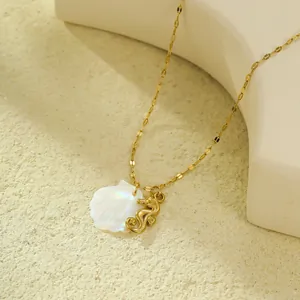 Détail macro d'un pendentif hippocampe doré et nacre sur une chaîne de collier délicate