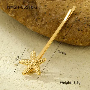 Macro detail of a 6.2cm golden starfish hair clip with realistic textures on a beach rock
