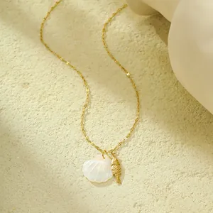 Gros plan d'une chaîne à paillettes dorées avec pendentifs coquillage et poisson