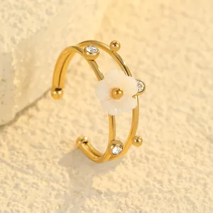 Detailed view of an 18K gold plated titanium steel ring with shell flower and zircons.