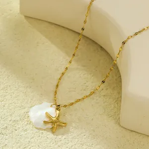 Détail du pendentif étoile de mer dorée sur coquillage blanc et chaîne en or
