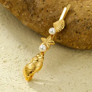 Macro detail of golden seashell and starfish hair clip with pearls on natural rock