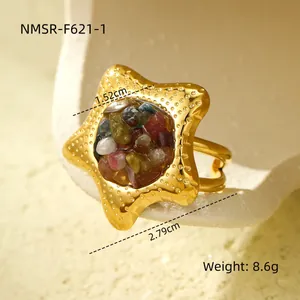 Macro-opname van gouden stervormige ring met gekleurde stenen en fijne textuur
