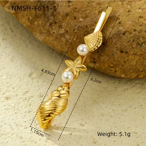 Detail of gold seashell and starfish hair clip with pearls on a natural rock background