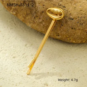 Detailed view of a gold shell-shaped hair clip with pearls on natural rock background