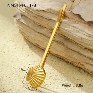 Macro shot of gold shell hair clip showing 1.5cm dimensions on a rocky texture background