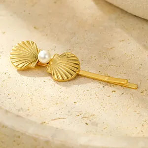 Macro shot of gold seashell hair clip featuring detailed shell motifs and white pearl detail