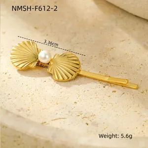 Detailed macro view of a golden scallop shell hair clip with central pearl and dimensions