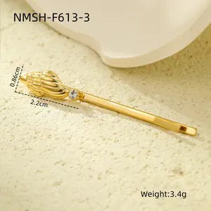 Detailed view of a gold conch hair clip with pearl and dimensions 2.2cm by 0.86cm