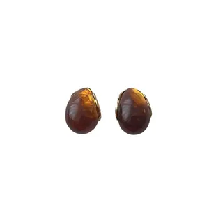 French vintage amber resin teardrop earrings with gold metal accents on white background