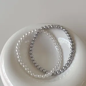 Gros plan de bracelets en perles avec détails en zircon sur plat en céramique