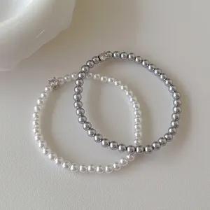 Détail de bracelets en perles avec zircons en blanc crème et gris métallique élégant