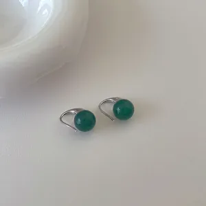 Nahaufnahme von smaragdgrünen Achatperlen auf silbernen Metallohrringen für Eleganz