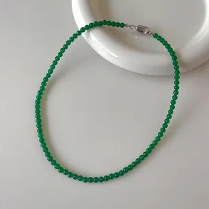 Dettaglio della collana di perline di calcedonio verde con fibbia in argento su vassoio