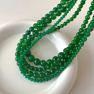 Vista macro di perle di calcedonio verde che mostrano la trama lucida e i toni smeraldo