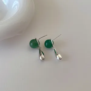 Makro-Detail von smaragdgrüner Perle und poliertem silbernem Tropfen-Ohrstecker