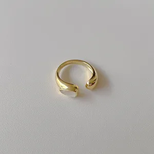 Detailed shot of golden open ring featuring a white teardrop shell inlay decoration