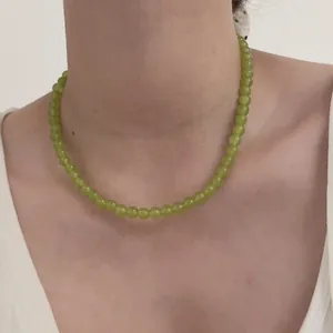 Detail of green beaded necklace with translucent gemstone beads on woman's neck