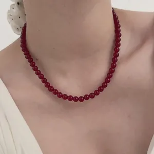 Close-up of elegant red agate beaded necklace worn on neck as a vintage collar chain