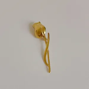 Macro shot of polished gold tulip brooch showing detailed petal and leaf craftsmanship
