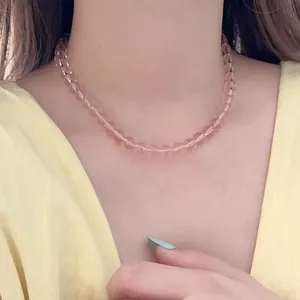 Detailed close-up of pink glass bead necklace with a subtle translucent gloss finish