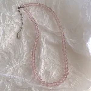 Detail of pink glass beaded necklace with durable stainless steel lobster clasp and chain